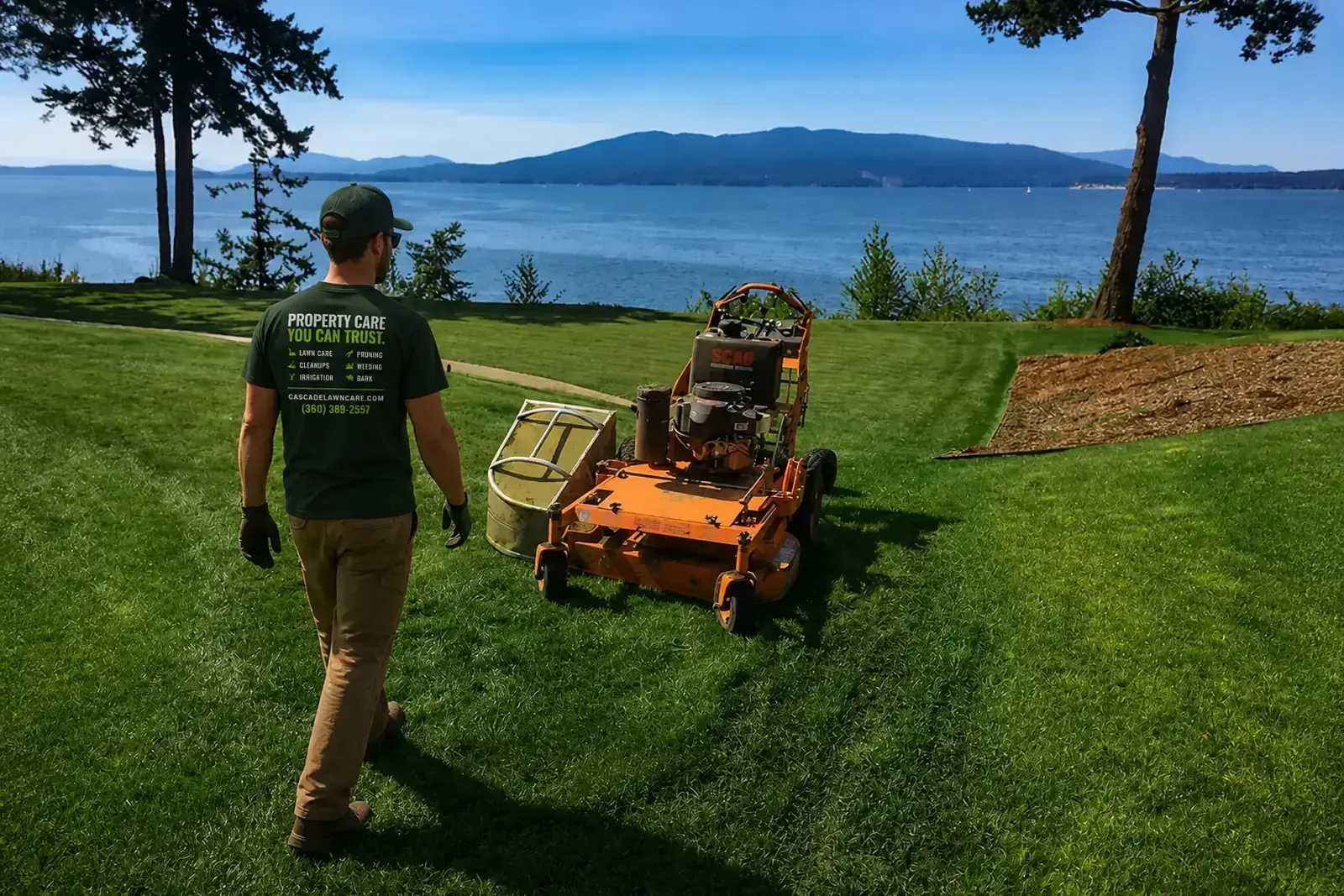 Cascade Lawn Care mowing a waterfront lawn above Bellingham Bay